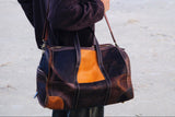 COFFT Signature patchwork leather duffle bag worn on shoulder with Latte and Espresso colorblock design
