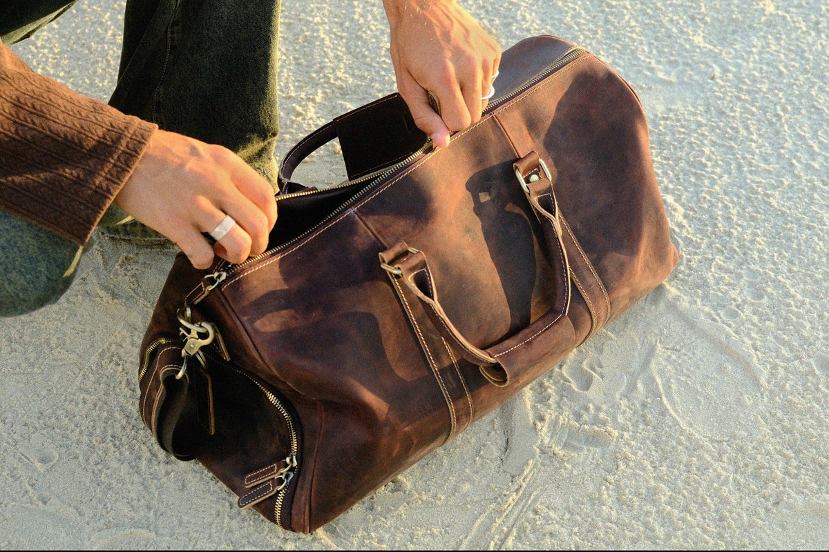 COFFT DUFFLE 01 Espresso leather bag being opened, showing zipper closure and spacious travel design