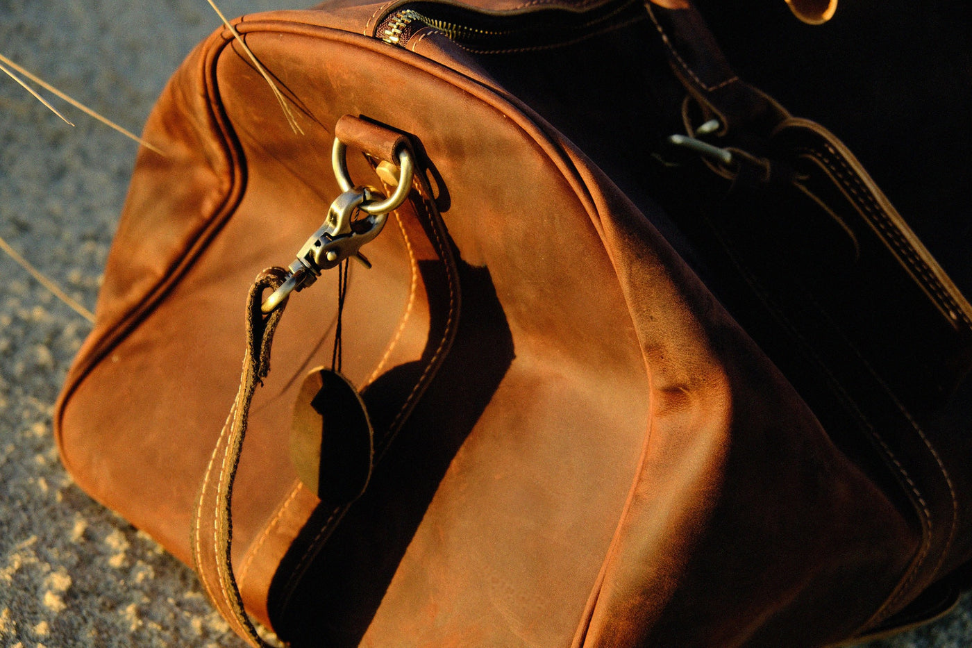 Close-up of COFFT DUFFLE 01 Espresso leather duffle bag with metal hardware and rich brown leather texture