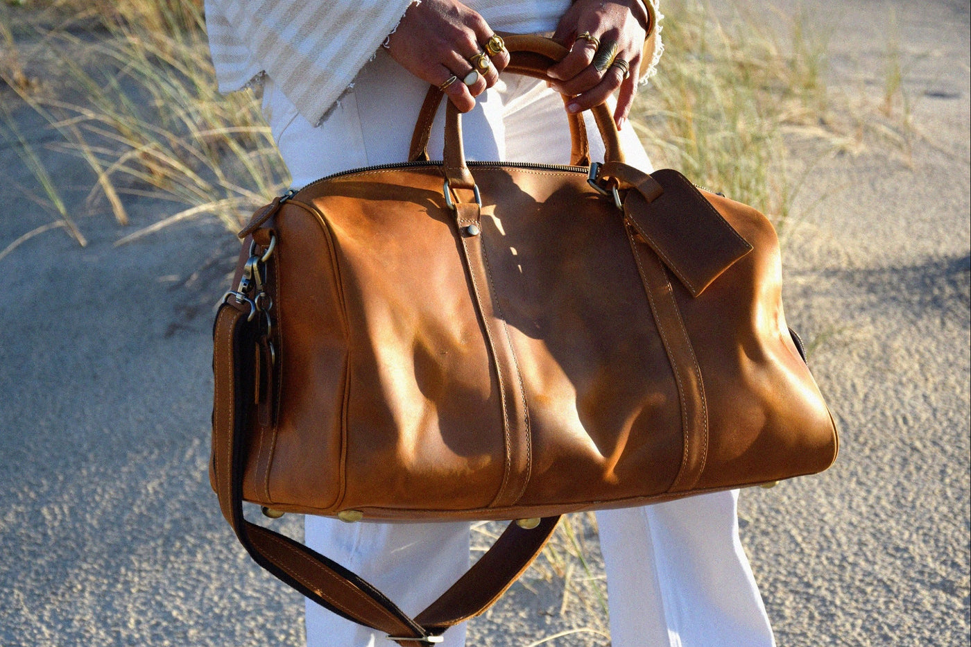 COFFT DUFFLE 01 Latte leather weekend bag styled with a white outfit in a refined outdoor lifestyle scene