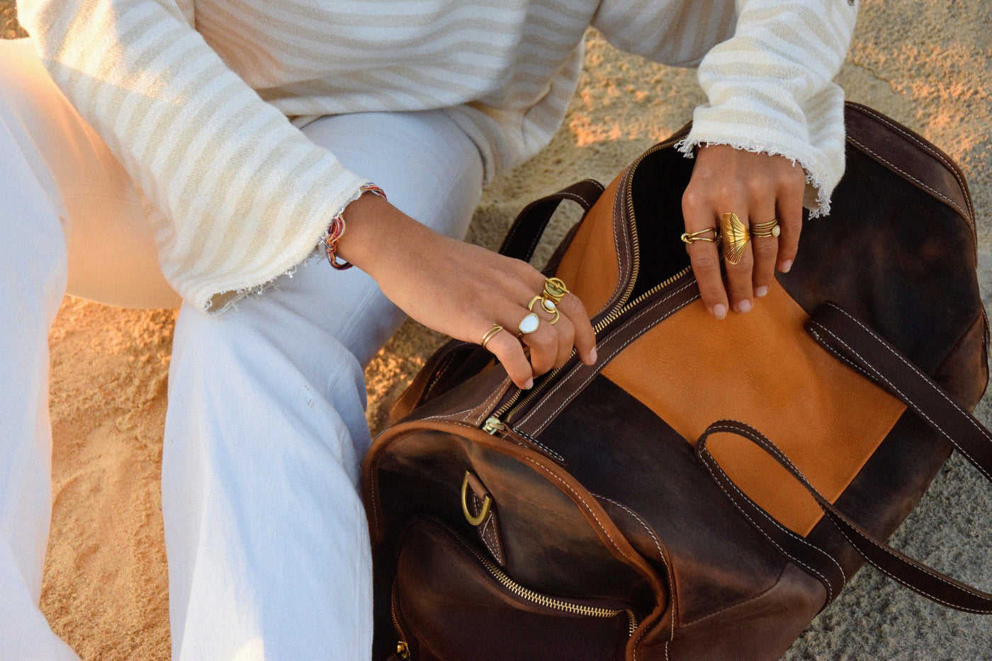 Top view of COFFT Signature patchwork leather duffle bag being opened, showing interior space and zipper detail