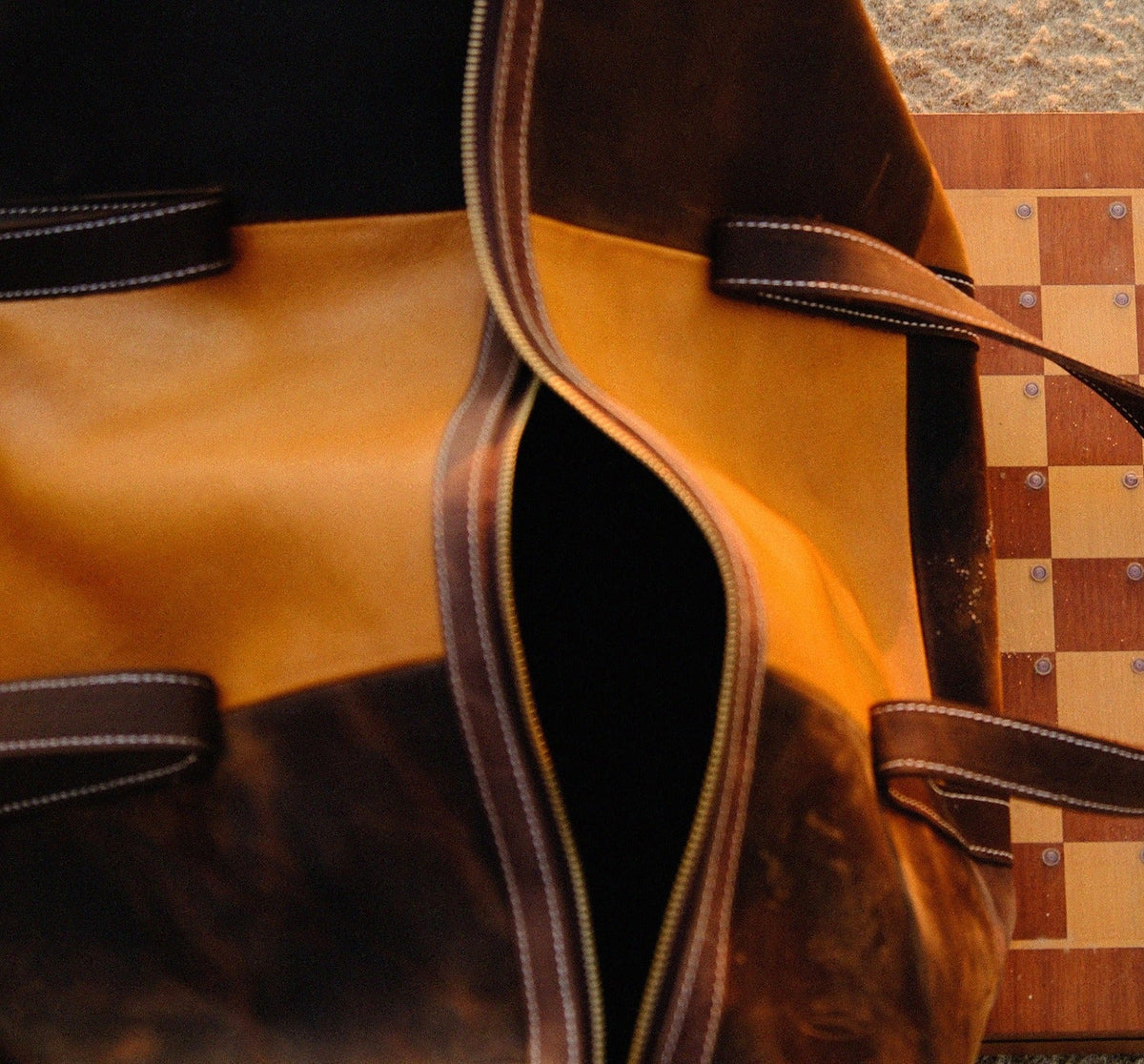 Top view of COFFT Signature patchwork leather duffle bag with chessboard, showing Latte and Espresso panels