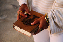 Close-up of COFFT leather notebook cover with embossed-style artwork and premium handmade texture