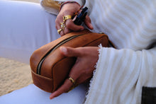 COFFT Latte leather pouch close-up with zipper, hand detail, tan leather finish and minimalist everyday design