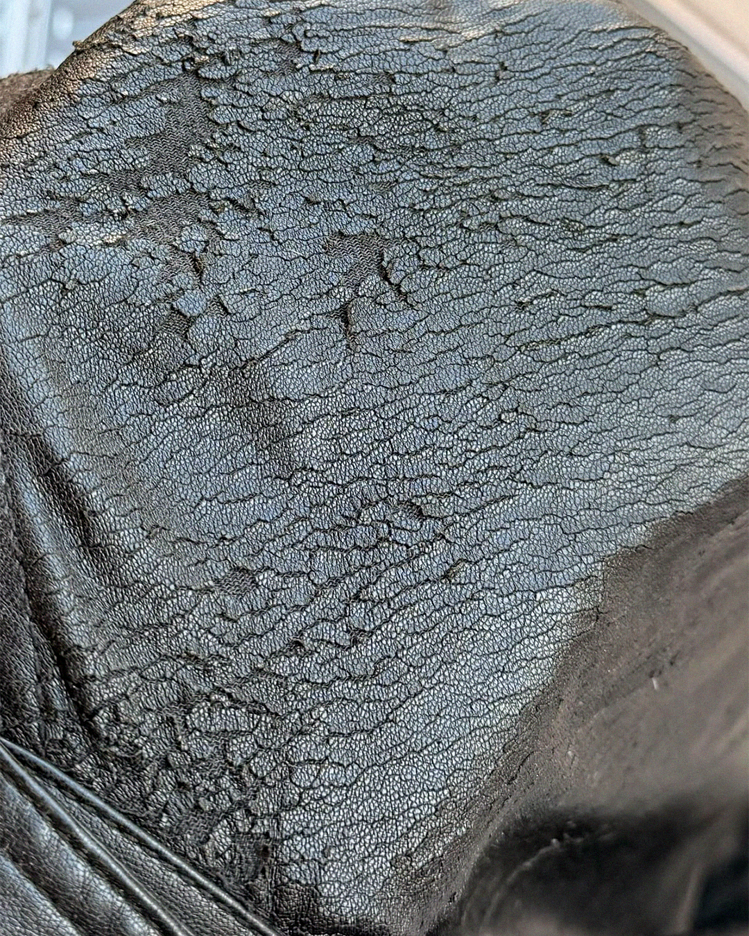 Close-up of PU leather coating lifting near a seam